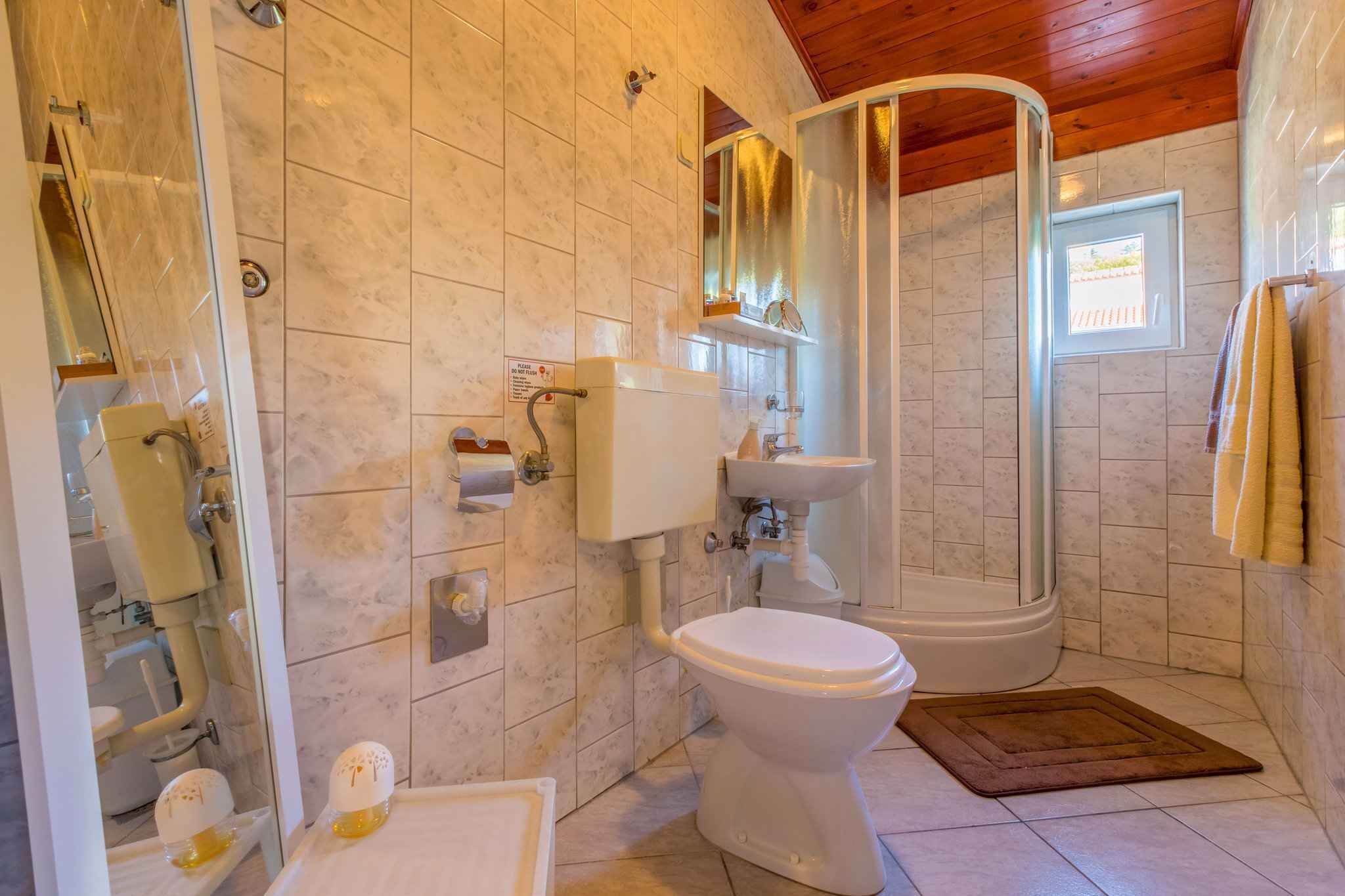 A bathroom with a toilet, sink, and shower.