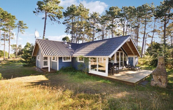 Escape to a serene retreat surrounded by a lush forest, with a spacious deck perfect for dining or relaxation.