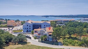 Ein Küstenwohngebiet mit modernen Geb äuden, einem Parkplatz und Blick auf das Meer.