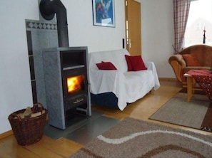 Una sala de estar con chimenea, un sofá, una silla y una alfombra.