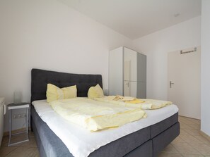 Une chambre à coucher avec un lit, une table de chevet et une armoire.