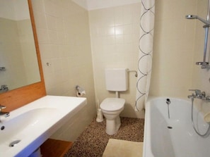 A bathroom with a sink, toilet, bathtub, and shower curtain.