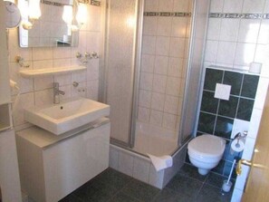 Une salle de bain avec un lavabo, un miroir et une douche.