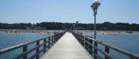 A wooden pier extending into a body of water with a clear sky above.
