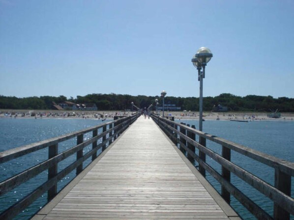 A wooden pier extending into a body of water with a clear sky above.
