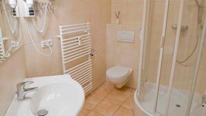 Un baño con lavamanos, inodoro y ducha.