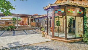 Una casa moderna con un patio, una piscina y un salón acristalado con ventanas de colores.