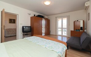 A bedroom with a bed, a television, a wardrobe, a sofa, and a balcony. - 4 bedroom stunning apartment in Poljana (Poljana)