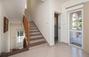 Eine Treppe mit hölzernen Spindeln, einer weißen Wand und einer Tür zu einem Waschraum.