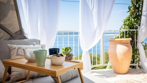 A balcony with a table set for tea, a potted plant, and a large terracotta pot. - Lovely home in Crikvenica with WiFi (Crikvenica)