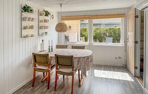 Un comedor con una mesa redonda, cuatro sillas y una lámpara colgante.