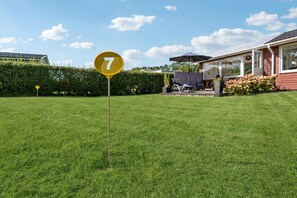 Une pelouse bien entretenue, avec un panneau jaune portant le chiffre « 7 », dans un quartier résidentiel.