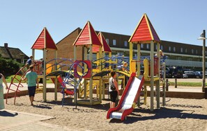 Ein Spielplatz mit Klettergerüsten, Rutschen und einem Sandbereich.