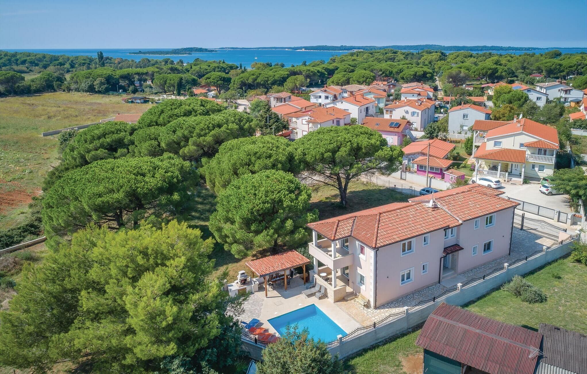 Um bairro residencial com casas, piscina e vista para o mar.
