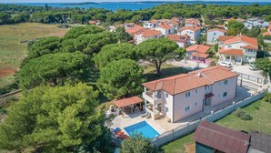 A residential area with houses, a swimming pool, and a view of the sea. - Beautiful apartment in Valbandon (Valbandon)