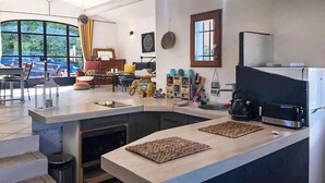 A modern kitchen with a curved island, a built-in oven, and a coffee machine. - 2 bedroom stunning home in Apt (Apt)
