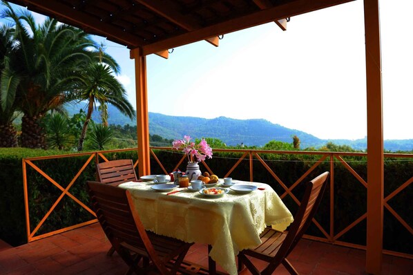 Mesa al aire libre con vista a montañas y palmeras.