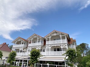 Un bâtiment à deux étages, doté d’un balcon à l’étage supérieur, d’un porche avant couvert et d’un toit recouvert de tuiles rouges.