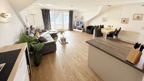 Een modern appartement met een woongedeelte, eethoek en keuken.