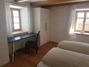 A room with a desk, chair, two beds, a window, and a wardrobe. - Apartment G1 - Apartments Garhammer, Kreuth-glassworks (Kreuth)