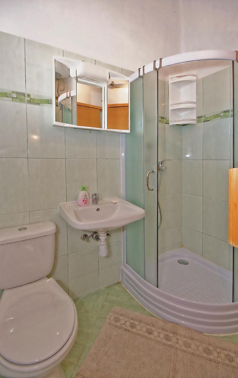 Ein Badezimmer mit Toilette, Waschbecken und einer Duschkabine.