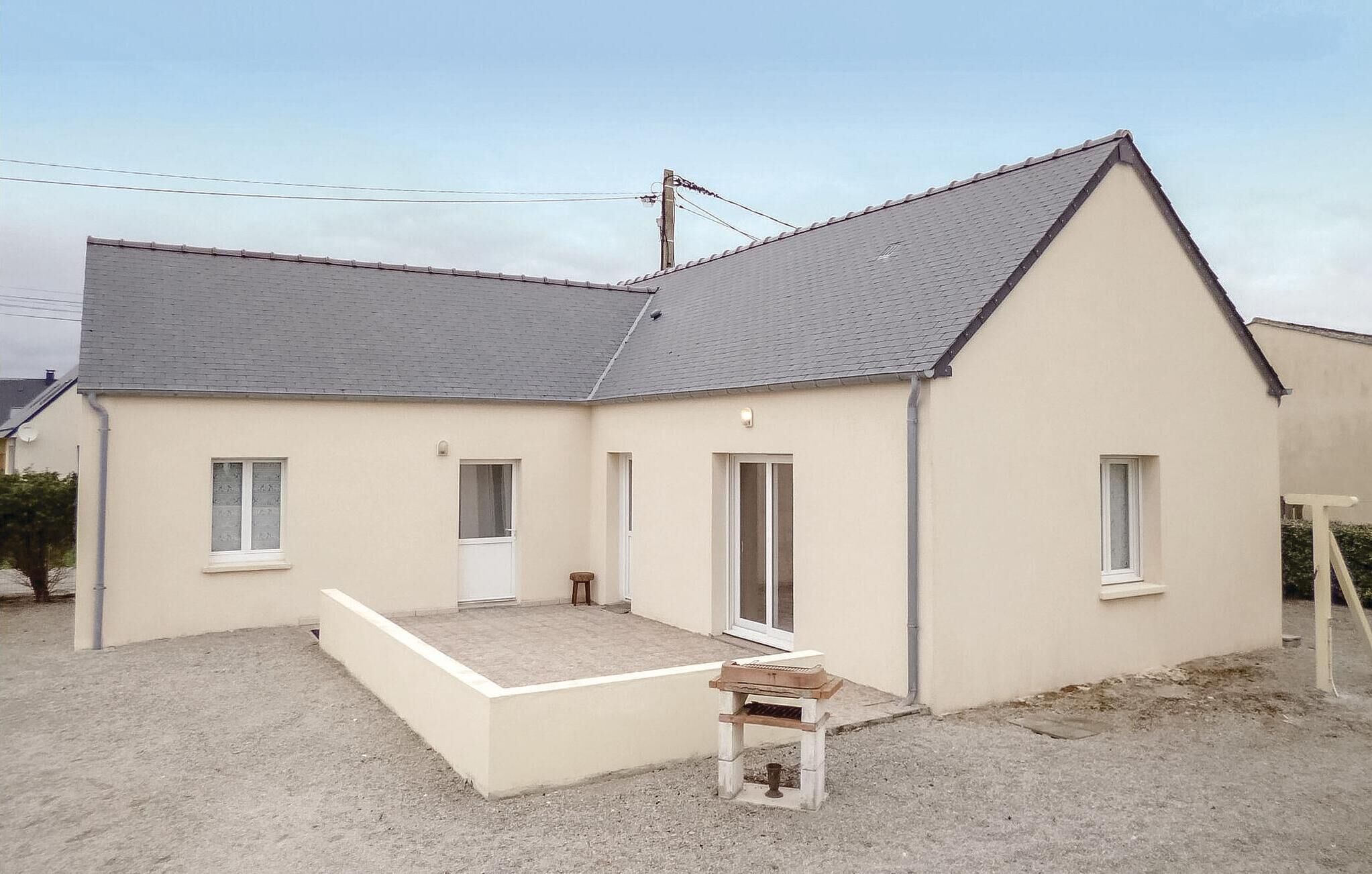 A two-story building with a sloped roof, a small porch, and a gravel driveway.