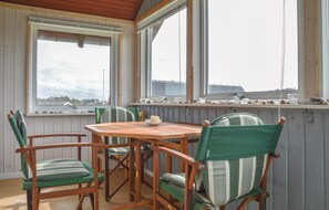 A wooden table with chairs in a room with large windows overlooking a body of water. - 1 bedroom nice home in Ringkøbing (Ringkøbing)