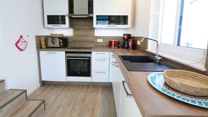 A compact kitchen with white cabinets, a built-in oven, a microwave, and a coffee maker. - CSP: Villa Anni Whg. 06 with balcony - Villa Anni Whg. 06 with balcony (Göhren)