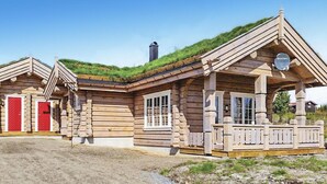 A log cabin with a green roof, a porch, and a red door. - Sjusjøen Setegrend 4733 (Sjusjøen)