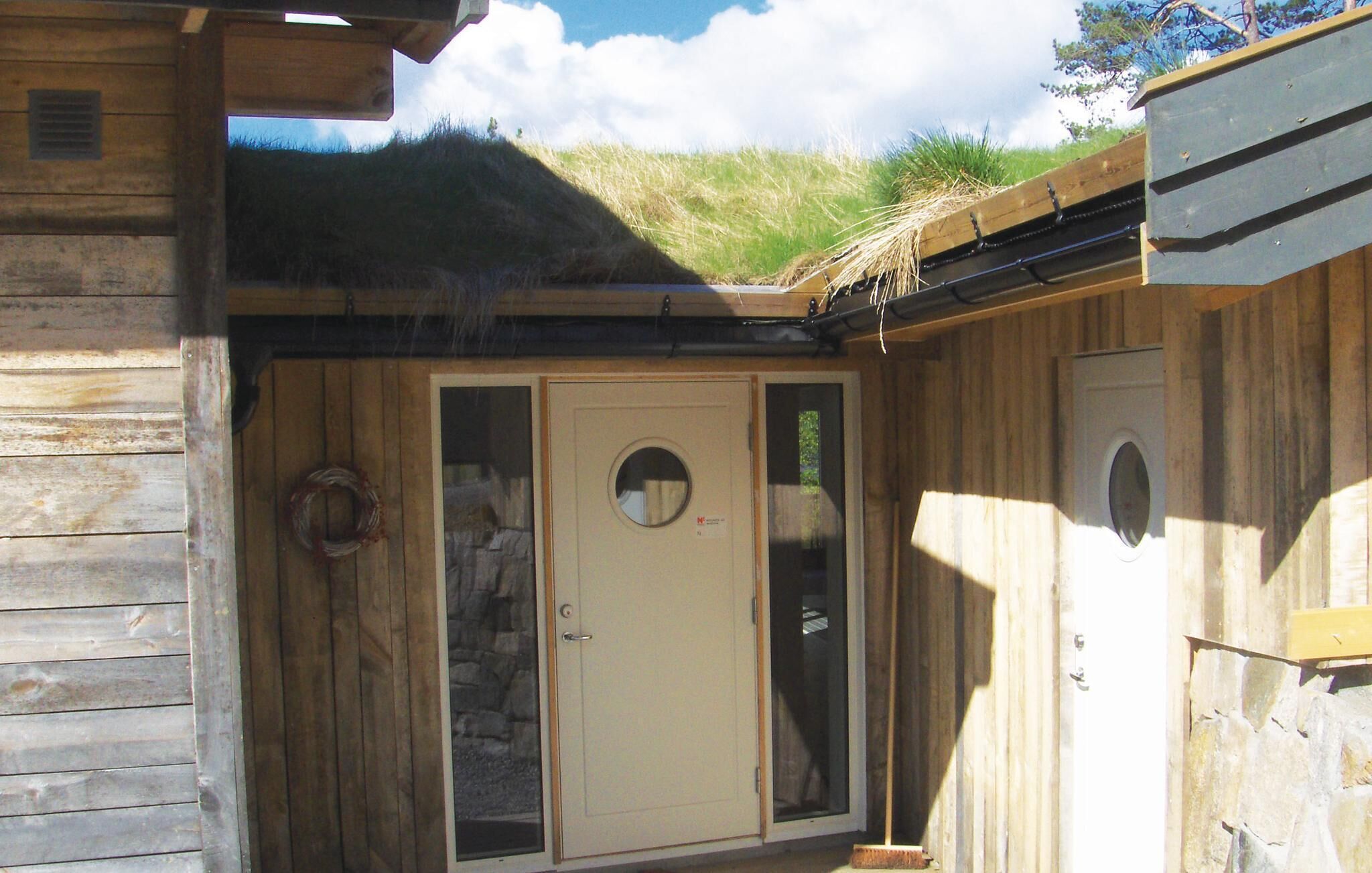 A wooden cabin with a door, a window, and a small porch area.