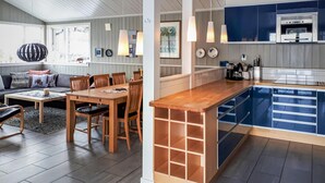 A modern kitchen with a built-in island, wooden dining table, and chairs.