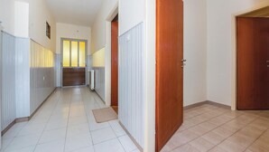 A hallway with white tiled flooring, wooden doors, and a radiator. - Gorgeous home in Lozovac (Lozovac)