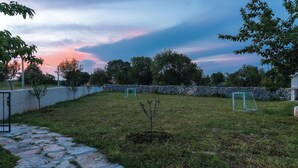A grassy outdoor area with a stone wall, a metal gate, and a soccer goal. - Gorgeous home in Lozovac (Lozovac)