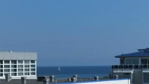 A building with a flat roof, large windows, and a view of the sea. - (157) 1- room apartment - apartment complex Yachthafenresidenz (Kühlungsborn)