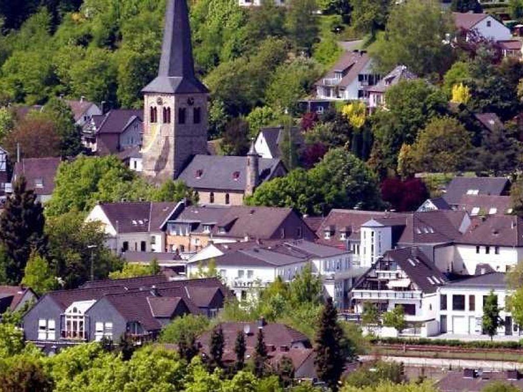 A residential area with houses, a church, and a tower.