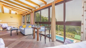 Ein geräumiger Raum mit großem Fenster, Pool und Holzboden.