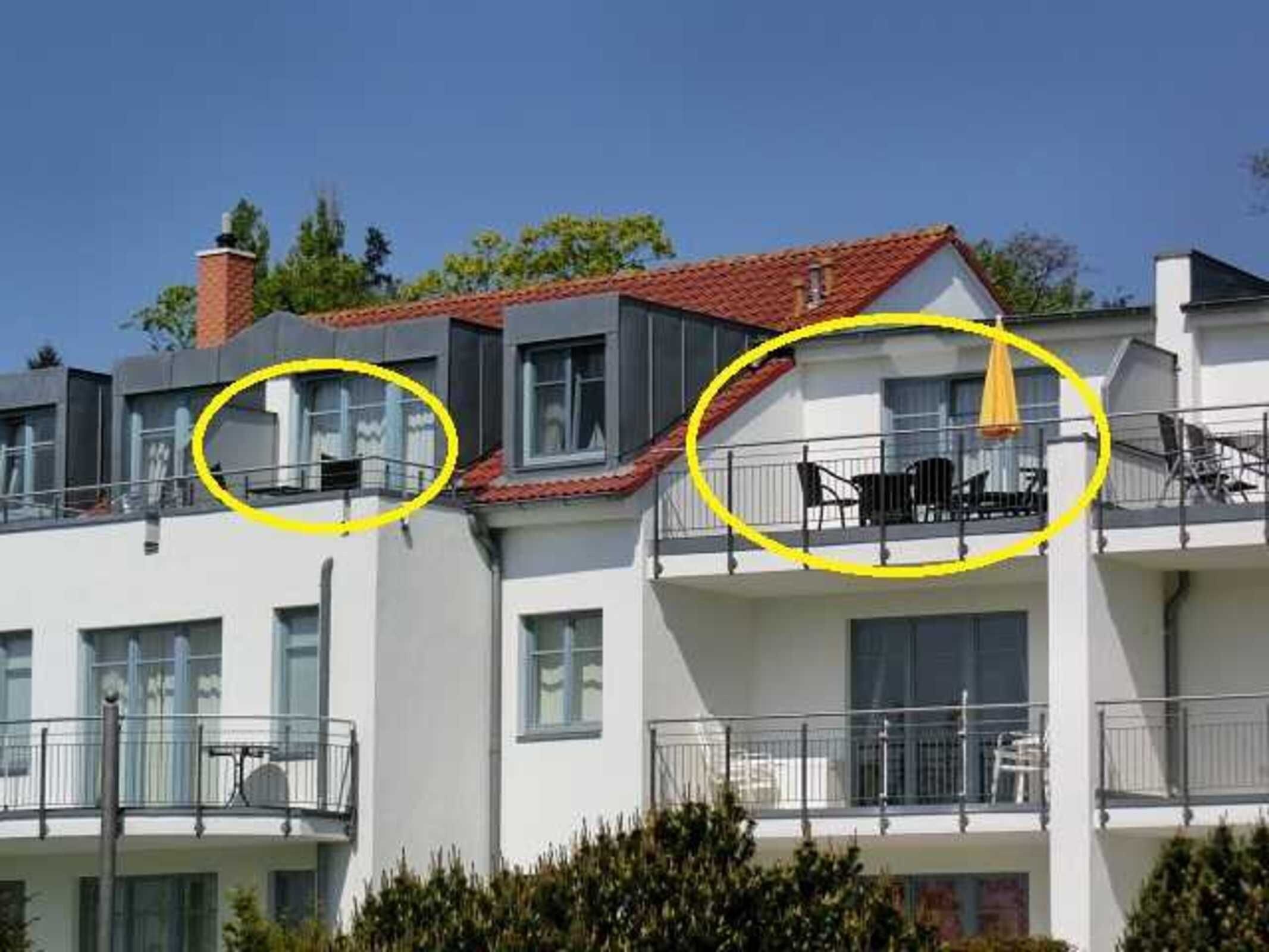 Un edificio a più piani con balconi, un camino e cielo sereno.