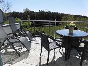 A balcony with outdoor furniture, a round table, and a potted plant. - Apartment 52 Residence Bellevue Usedom DSL-WLAN free of charge - Apartment 52 (Zinnowitz)