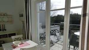 Una habitación con una mesa, sillas, un ventanal y vistas al exterior.
