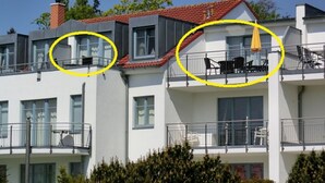 Un edificio de varios pisos con balcones, ventanas y una chimenea.