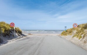 A coastal road with no parking signs, a speed limit sign, and a beach in the background. - 2 bedroom beach front home in Bindslev (Bindslev)
