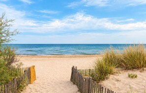 A sandy beach with a wooden fence leading to the water, under a clear sky. - Stunning home in Vias (Vias)