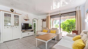 A modern living room with a TV, sofa, and coffee table. - Stunning home in Vias (Vias)