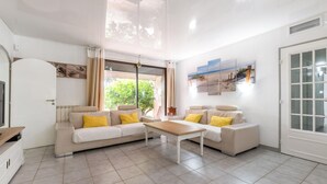 A spacious living room with a sofa set, a coffee table, and a large window with curtains. - Stunning home in Vias (Vias)