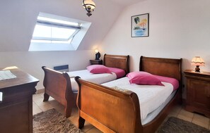 A bedroom with two wooden beds, a desk, a chair, a small table, a nightstand, a lamp, a painting, and a skylight. - Beach front apartment in Clohars Carnoet (Clohars Carnoet)