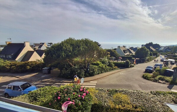 A residential street with houses, a tree, and a clear sky. - Beach front apartment in Clohars Carnoet (Clohars Carnoet)