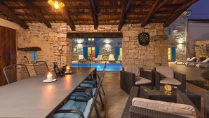An outdoor patio with stone walls, a pool, and lounge chairs. - Pet friendly home in Kringa (Kringa)