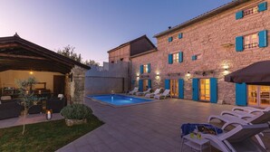 A courtyard with a swimming pool, outdoor seating, and a stone building with blue shutters. - Pet friendly home in Kringa (Kringa)