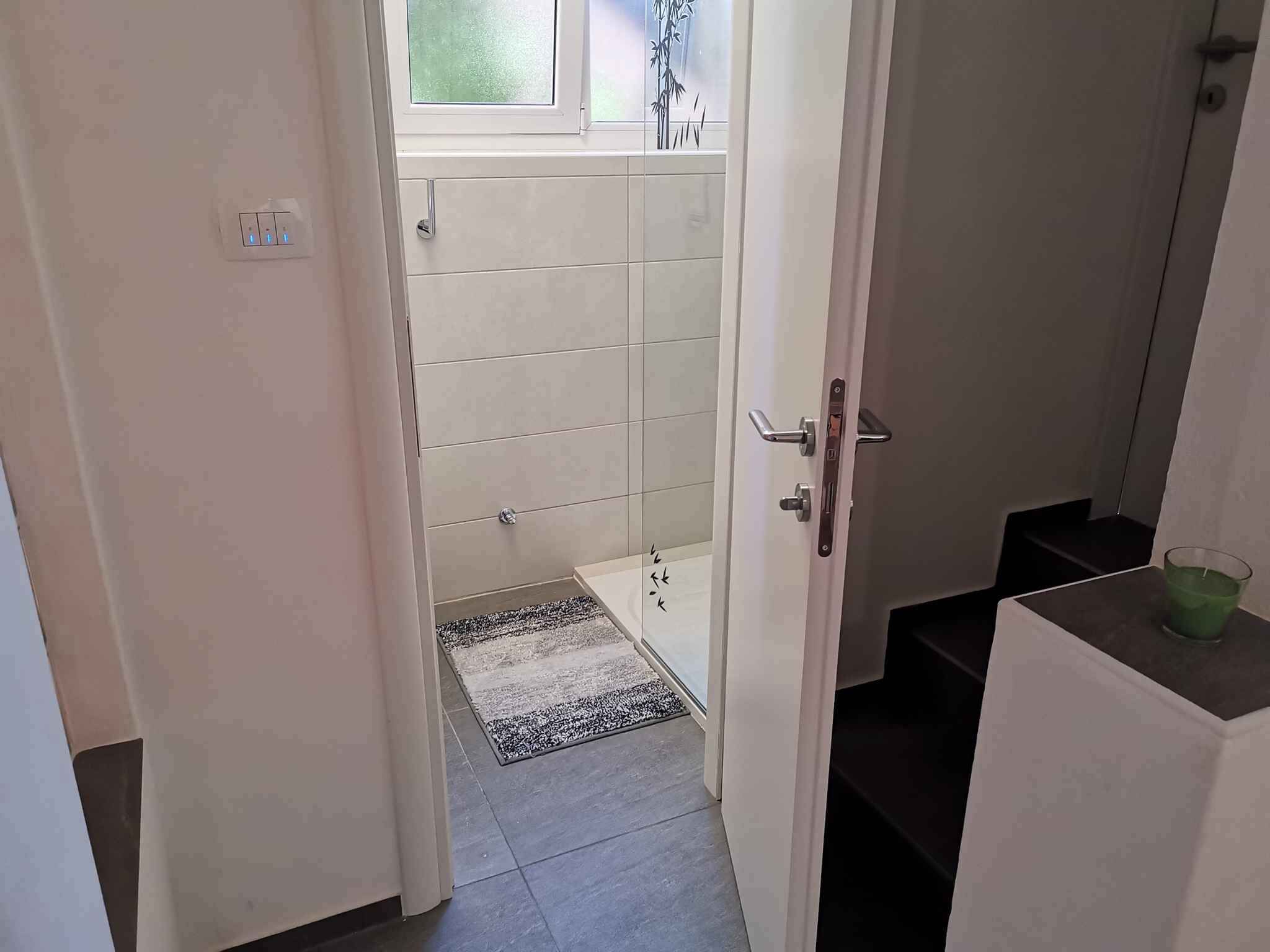 A bathroom with a shower, a toilet, and a sink.