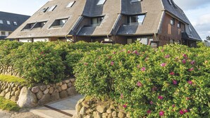 A modern building with a sloped roof and multiple windows. - Nautilus 12 from A&M - Nautilus 12 (Kampen (Sylt))